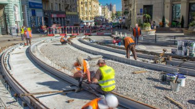 Sokak saatlerinde tamirat işe yarar. Şehir caddesinde yeni tramvay rayları döşemek. İşçiler cıvataları sıkılaştırır. Tramvaylar için yeni modern tren rayları monte edildi. Kavşaktaki tramvay raylarının yeniden inşası