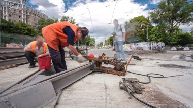 Tramvay rayları onarımı ve bakım zamanı olan bir yol inşaatı. Şehir caddesinde yeni raylar kesiyorum. Kavşağın ortası. Yeni toplu taşıma için demiryolu raylarının değiştirilmesi
