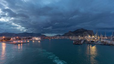 Gün batımından sonra açık denizde seyreden dalgalı ve limanlı deniz manzarası. Palermo kıyısı, İtalya