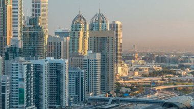 Dubai Yat Limanı gökdelenler hava üstten görünüm Jlt üzerinden sabah Dubai timelapse, BAE güneş doğarken sırasında. Modern kule uzun gölgeler aşağıya taşınması ve Şeyh zayed yolu üzerinde trafik ile.