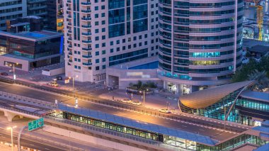 Dubai Yat Limanı gökdelenler ve tramvay istasyonu hava üstten görünüm güneş doğmadan önce Jlt gelen Dubai gece gün timelapse, Birleşik Arap Emirlikleri için. Işıklı modern kuleleri ve Şeyh zayed yolu üzerinde trafik.