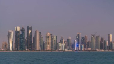 Arap şehri Doha 'nın ufuk çizgisi gece gündüz Katar' daki geçiş zamanı, gün doğumundan hemen önce aydınlık gökdelenlerle yakalandı. Corniche Gezinti Alanından Görünüm