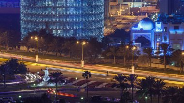 Doha Corniche ve kahve demliği anıtı. Havadan görünüşlü. Arka planda aydınlık gökdelenler ve yolda trafik