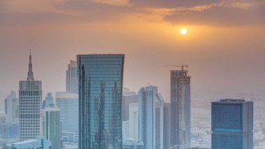 Günbatımında gökdelenler başkent Katar 'ın ticaret merkezi Doha' nın ufuk çizgisinde. Sisli havada hava manzarası. Bulutlu turuncu gökyüzü