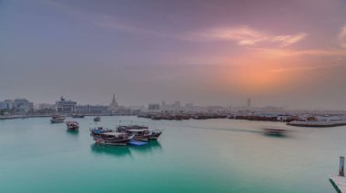 Geleneksel ahşap Dhow balıkçı tekneleriyle Doha Körfezi 'nde gün batımı. Corniche, Doha, Katar ile müzeden görüntü