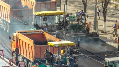 Çalışan işçiler finişer makineleri ve bahşiş asfalt yol yapımı sırasında ve tamir timelapse izleme ile çalışır