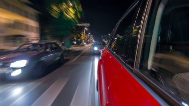 Hızlı arabanın yanından gelen bir saçmalık. Bir gece caddesinde hızla ilerliyor. Işıklar yüksek hızda arabaya yansıyor. Modern bir şehrin hızlı ritmi. Bulanık hareket