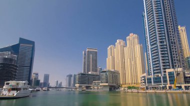 Yatı ve tekneleri olan Dubai Marina gökdelenleri. Rıhtımdan mavi gökyüzü ile hiper hıza geç