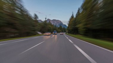 Avusturya, bir güzel sonbahar günü timelapse hyperlapse drivelapse Alpler'de asfalt yolda sürücü. Orman ve dağlar akşam