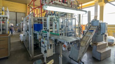 Mavi plastik bir teneke kutu üretimi için bir fabrika. Fabrikadaki taşıyıcı. Çevre dostu üretim.