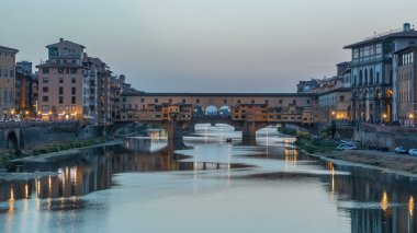 Arno Nehri ve Ponte Vecchio Köprüsü. Gün batımından sonra İtalya 'nın Toskana kentindeki Floransa' daki Ponte alle Grazie 'den geçiş zamanı. Akşamları nehire yansıyan yansıma