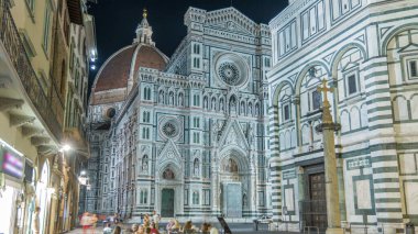 Basilica di Santa Maria del Fiore 'un gece manzarası. İtalya 'daki Floransa Katedrali (Duomo) kilisesi. Akşam aydınlatması. Çan kulesi ve kubbe. Dışarıdaki restoranda oturan insanlar.