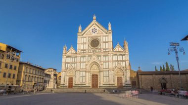 Floransa 'da Santa Croce Meydanı' nda gün batımından önce Santa Croce Bazilikası (Santa Croce Bazilikası) ile birlikte yürüyen turistler. Kilise ünlü İtalyanların gömüldüğü yerdir..