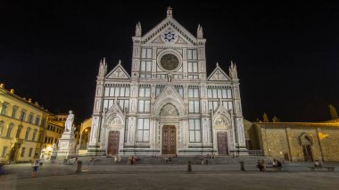 Floransa 'da Santa Croce Meydanı' nda gece vakti yürüyen turistler, Basilica di Santa Croce (Kutsal Haç Bazilikası) ile son sürat gidiyorlar. Kilise ünlü İtalyanların gömüldüğü yerdir..