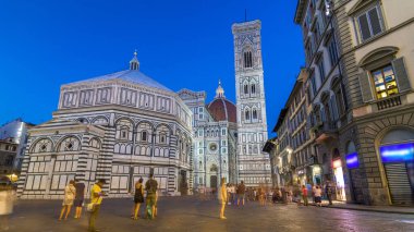 Basilica di Santa Maria del Fiore and Baptistery San Giovanni day to night transition timelapse. Cathedral church (Duomo) of Florence in Italy. Evening illumination. Bell tower and dome after sunset clipart