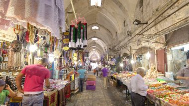 Eski Kudüs şehrindeki renkli çarşıda yürüyoruz İsrail zaman kavramının aşırı hızlanması. Bu pazarda bir sürü insan geçiyor.