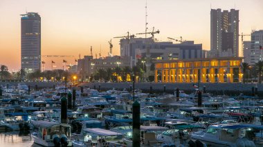 Sharq Marina 'da yatlar ve tekneler. Kuveyt' teki geçiş zamanı gece gündüz gökyüzü. Kuveyt Şehri, Orta Doğu. Suya yansıyan modern kuleler