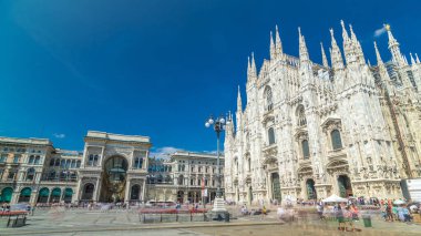 Cathedral Duomo di Milano and Vittorio Emanuele gallery timelapse hyperlapse in Square Piazza Duomo at sunny summer day, Milan, Italy. People walking on the square. Blue cloudy sky clipart