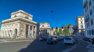 Tarihi eser Porta Venezia hiperlapse (Buenos Aires Bulvarı 'ndaki kavşak ve Bastioni di Porta Venezia caddesi). Milan, İtalya. Yollarda trafik vardı. Yazın mavi gökyüzü