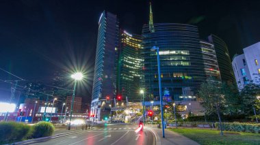 Milan Porta Nuova iş ilçe gece timelapse, Milano, İtalya içinde modern gökdelenler ile manzarası. Yolda trafik. Işık içinde pencere eşiği. Yoldan görüntülemek