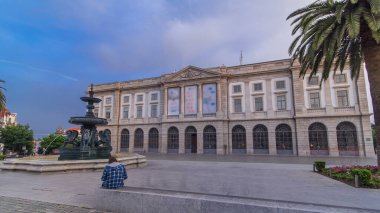 Natural History Museum of Porto University building front view in Gomes Teixeira Square with fountain and palm timelapse hyperlapse before sunset. Porto, Portugal