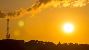 Rome at sunset timelapse with the fiery orb of the sun dropping below the horizon above the rooftops of the historical buildings. view from the Pincio Landmark with tv tower clipart