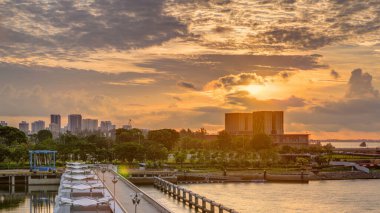 Marina Barrage 'da güzel bir gün doğumu zamanı. Turuncu gökyüzü ve güneş ışınlı bulutlar. Singapur 'un 15. su deposu ve şehrin göbeğindeki ilk su deposudur..