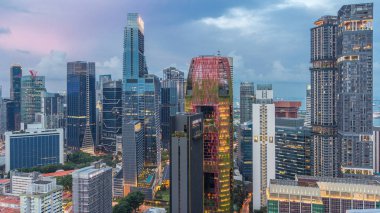 Singapur 'daki şehir merkezinin havadan görünüşü günden geceye geçiş zamanı çatıdan. Modern kuleler ve gökdelenler akşam aydınlandı.