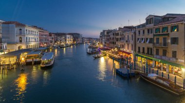 Grand Canal in Venice, Italy day to night transition timelapse. Panoramic view on gondolas and city lights from Rialto Bridge. Beautiful and romantic Italian city on water. clipart