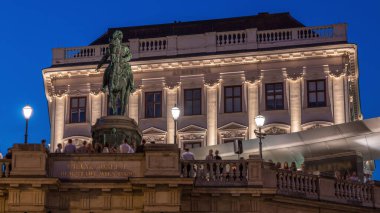 Night view of equestrian statue of Archduke Albert in front of the Albertina Museum day to night transition timelapse in Vienna, Austria. Illuminted buildings on a background clipart