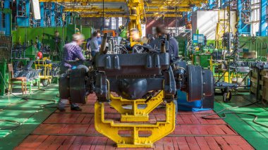 Konveyör montajı, traktörün gövdesini büyük endüstriyel fabrika zaman diliminde sahneleyecek. Çerçeve montajı, çamurluk kurulumu ve diğer bölümler.