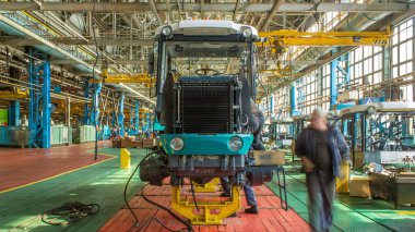 Konveyör montajı, traktörün gövdesini büyük endüstriyel fabrika zaman diliminde sahneleyecek. Çerçeve montajı, radyatör ve kabin kurulumu ve diğer parçaları olan motor.