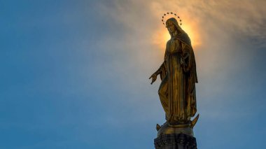 Holy Mary monument with sun behind it on square in front of the Cathedral timelapse in Zagreb, Croatia. Close up view. Blue sky at sunny day.