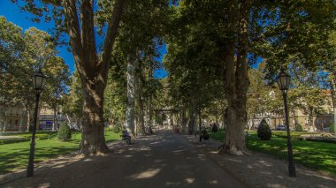 People walking around pavillion in Zrinjevac park timelapse hyperlapse in Zagreb, Croatia. Zrinjevac is spread over 12540 sq meters in city center. People relaxing on a bench