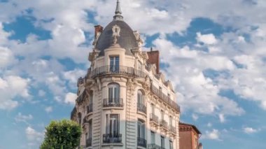 Fransa 'nın Toulouse şehrinde Rue du Languedoc ve Theodore Ozenne kavşağındaki tarihi cephelerde. Mağazalar, Carmes metro istasyonu yakınlarındaki kafeler canlı şehir merkezinde bulutların altında mavi bir gökyüzünde