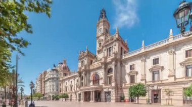 Valencia Belediye Binası Ajuntament de Valencia zaman atlaması Plaza de Ayuntamiento 'da. Mavi gökyüzünün altında saat kulesi olan tarihi bir bina. İspanya 'nın ana meydanında gezinen insanlar