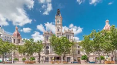 Valencia Belediye Binası Ajuntament de Valencia zaman atlaması Plaza de Ayuntamiento 'da. Mavi bulutlu gökyüzünün altında saat kulesi olan tarihi bir bina. İspanya 'nın ana meydanında gezinen insanlar