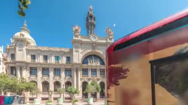 Valensiya 'daki tarihi posta ofisi Palau de les Comunicacions Belediye Meydanı Plaza del Ayuntamiento' da zaman atlaması. Süslü cephe, trafik ve İspanya şehir merkezinde mavi bir gökyüzü..