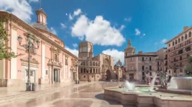 Valencias Plaza de la Virgen 'in panoramik zaman atlaması, Turia Fountain, Cathedral ve Basilica de la Virgen de los Desamparados' un mavi bulutlu gökyüzü altında sergilenmesi