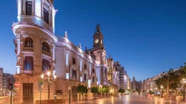 Valencia Belediyesi Ajuntament de Valencia Plaza de Ayuntamiento 'da günden geceye geçiş süreleri aşırı hızlanıyor. Saat kulesi olan tarihi bir bina. İspanya 'nın ana meydanında gezinen insanlar