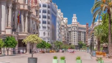 Valencia Belediye Binası Ajuntament de Valencia zaman kaplaması Plaza de Ayuntamiento 'da. Mavi gökyüzünün altındaki tarihi bina giriş kulesi. İspanya 'nın ana meydanında gezinen insanlar