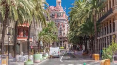 Valencia Bankası 'nın tarihi tarihi merkezi Valencia, İspanya' da. Göz kamaştırıcı bir mimari, palmiye kaplı bir sokak ve parlak mavi gökyüzü altında yoğun bir trafik. Şehir finans bölgesi sahnesi