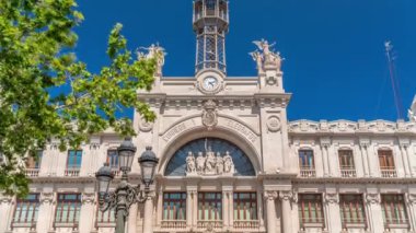 Valensiya 'daki tarihi posta ofisi Palau de les Comunicacions Belediye Meydanı Plaza del Ayuntamiento' da. Süslü cephe, yeşil ağaçlar ve İspanya şehir merkezinde mavi bir gökyüzü..