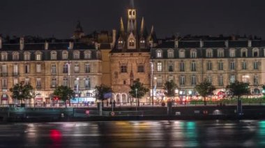 Ortaçağ mimarisi ve kuleleriyle Fransa 'nın Bordeaux kentindeki tarihi Porte Cailhau zaman dilimi manzarası. Gece sahneleri aydınlık kapıyı ve deniz manzaralı trafiği gösteriyor.