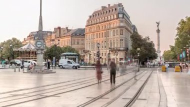 Günbatımında Place de la Comedie Timelapse, Bordeaux, Fransa 'da üçgen bina ve modern tramvay. Gölgeler ön cephede ilerler ve saatli bir sokak lambası bu şehir simgesine zarafet katar.