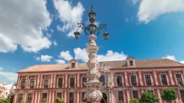Sevilla Başpiskoposu ve Fuente Farola çeşmesi Plaza de Virgen de los Reyes şehir meydanı hiperhızlandırılmış zaman aralığı. Tarihi mimarisi olan mavi bulutlu bir gökyüzü. Sevilla, Endülüs, İspanya.