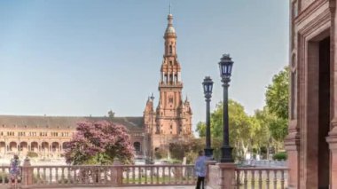 Seville 'de Espana Plaza de Espana, Ibero-American Exposition için inşa edilen Maria Luisa Park' taki büyük mimari kompleksin kulesi. Ağaçlar, kanallar ve mavi gökyüzünün altındaki klasik sokak lambaları.