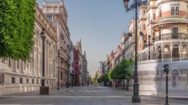 Avda boyunca yürüyen yayalar. De la Constitucion, Seville, İspanya 'nın Casco Antiguo bölgesindeki ana cadde. Edificio de la Adriatica yakınlarındaki zaman dilimi, tarihi binalar ve geçen tramvaylar