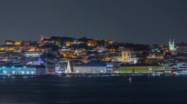 Lisbons Ticaret Meydanı 'nın zaman mekanı Noel için aydınlatıldı. Turistler, açılış ışık gösterisi sırasında parlayan ağacın ve dekorasyonların etrafında toplanıyorlar. Portekiz 'in başkentinde gece sahnesi