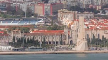 Mosteiro dos Jeronimos 'un hava zaman çizelgesi ve Lizbon' un Belem bölgesinde bulunan Keşifler Anıtı. Tejo Nehri 'nde tekneleri ve rıhtımdaki insanları olan manüel mimari.